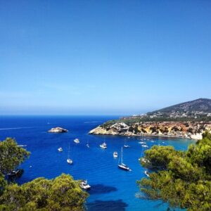 Cala in Ibiza island, Catamarans and sailing boats in the blue water