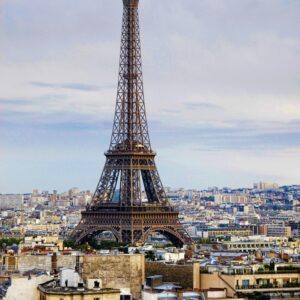 A captivating view of the Eiffel Tower rising above the Paris cityscape under a cloudy sky.