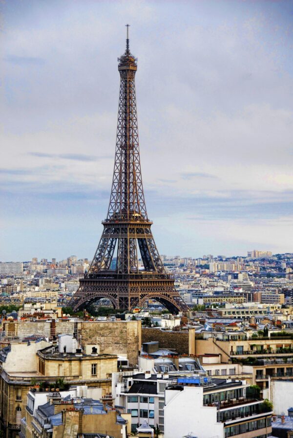 A captivating view of the Eiffel Tower rising above the Paris cityscape under a cloudy sky.