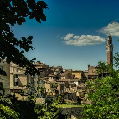 Tuscany Stunning view of Siena's medieval architecture under a bright blue sky.