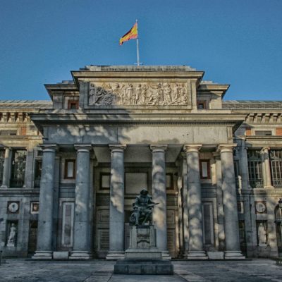 Museo del Prado Madrid Exterior of the Prado Museum in Madrid with a clear blue sky and statue in front.