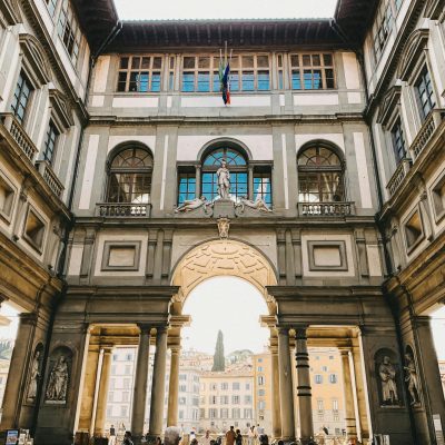Tourists exploring a famous architectural passageway in Florence, Italy.