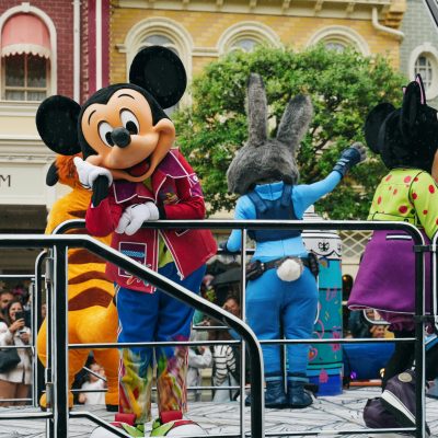 Vibrant Disneyland Paris parade with iconic Disney mascot characters entertaining the crowd.