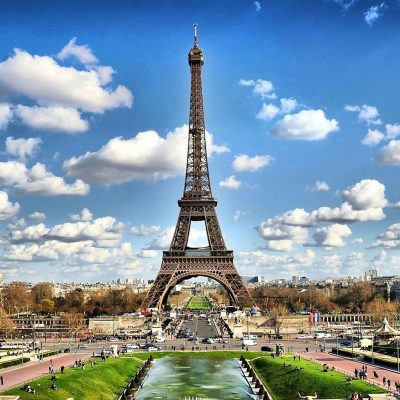 Stunning view of the Eiffel Tower with a backdrop of fluffy clouds and blue sky in Paris.